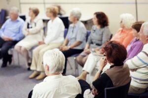 A group of seniors in a semi circle paying attention to someone at the front of the room